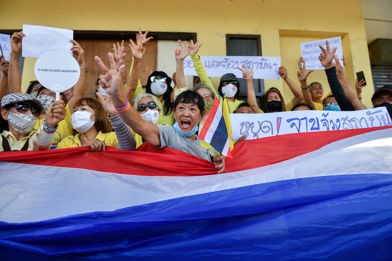 Pro-royalist supporters wearing yellow shirts wave a Thai national flag attend a rally to show their support for the monarchy and the government of Prime Minister Prayuth Chan-ocha at the Democracy Monument in Bangkok, Thailand. REUTERS/Chalinee Thirasupa